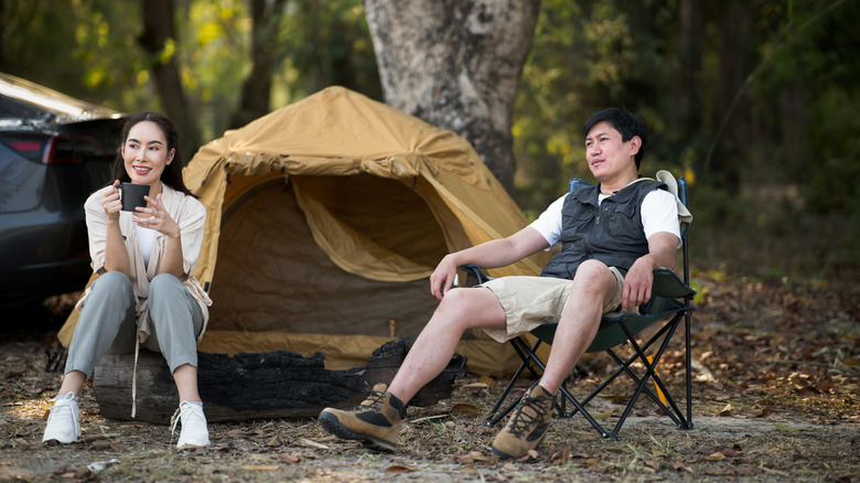 Couple sitting in camping chair around the campsite