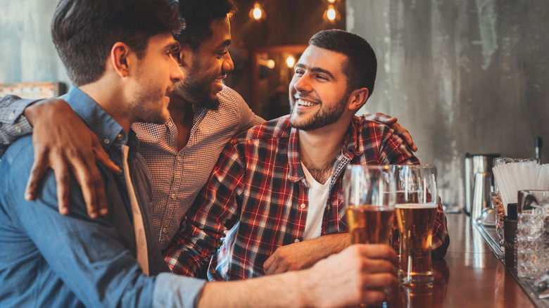 Three male friends drinking Guinness in a pub.