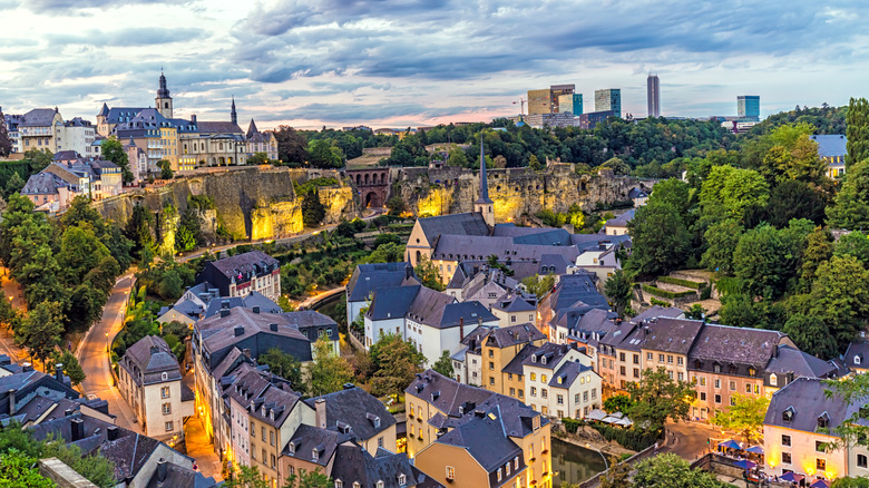 Cityscape of Luxembourg City with castle and high-rises, overlooking the old town, at sunset