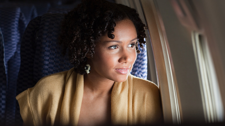 Woman looking out a plane window