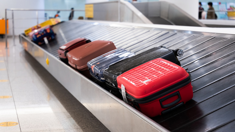 colorful bags on an airport carousel at baggage claim