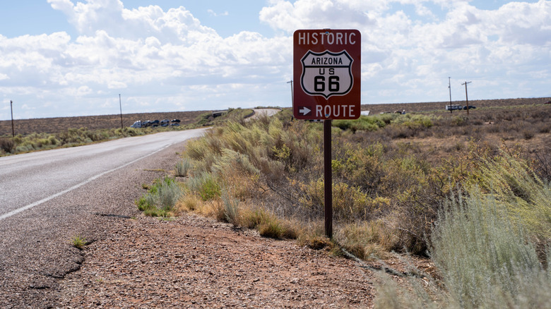 A classic brown Historic Route 66 sign points drivers along the original route in the Arizona desert