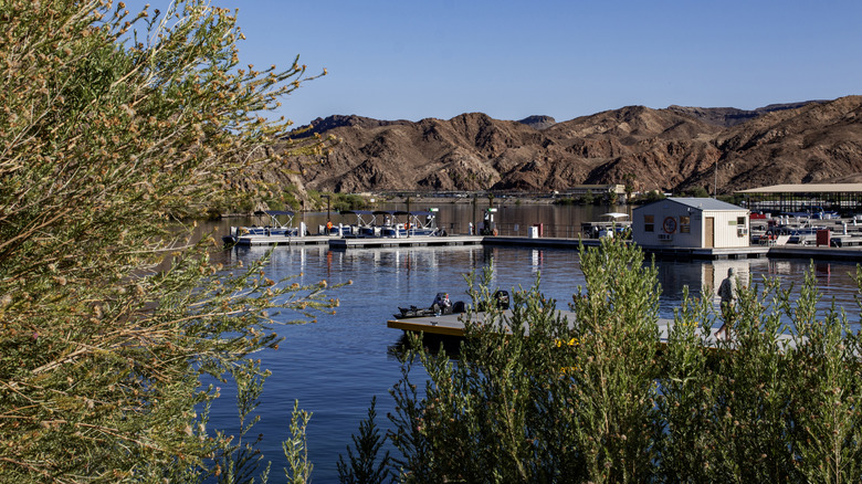 The serene lakeside setting of Willow Beach features boats docked and mountains surrounding the area