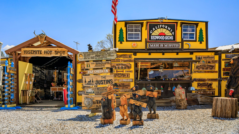 Souvenir shop in Oakhurst, California, with chainsaw-carved bears and signs near Yosemite National Park