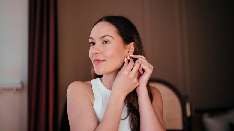 Woman putting earring on