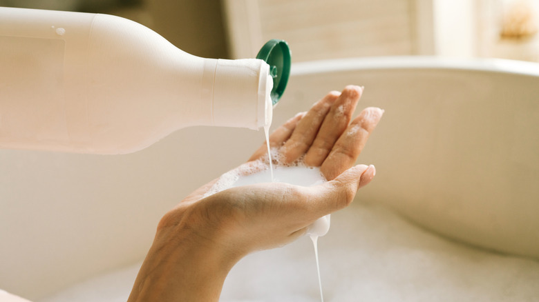 Shampoo falling out of bottle into a hand