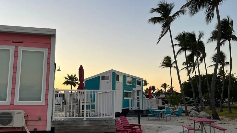 An image of colorful RVs at Tiny House Village in Key West in Florida along with scenic views of the ocean