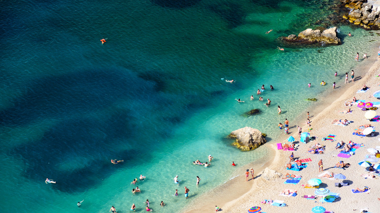 People sunbathe on the beach near to Villefranche-sur-Mer