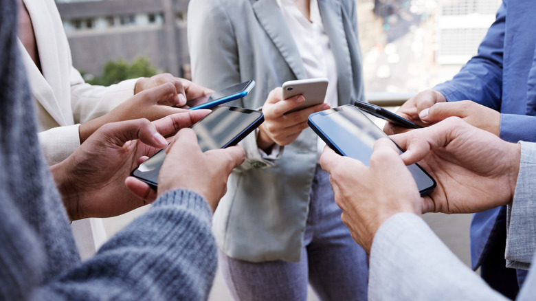 A group of people exchanging information using their phones