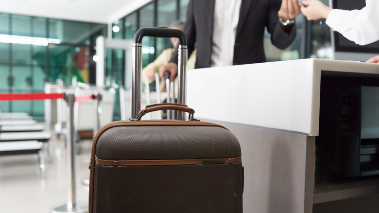 A person checking bag in the airport with focus on the luggage