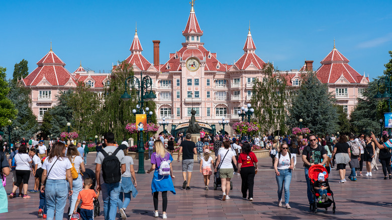 Person walking in front of the Disneyland Paris hotel in Marne-la-Vallée, France, on a summer day