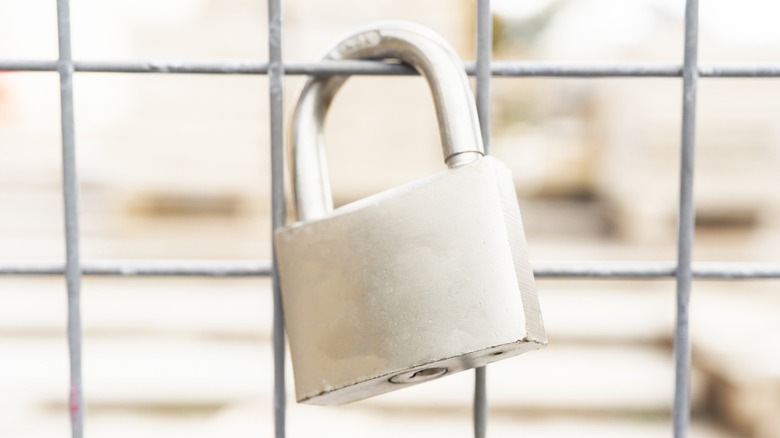 Closeup of grey padlock on gate