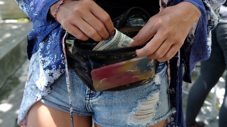 Closeup of a woman putting cash in her money belt