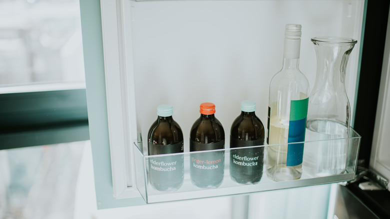 Wine, kombucha and water in fridge door