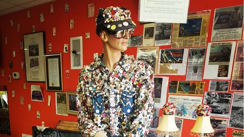 Mannequin covered in buttons and posters on the wall in Button Museum
