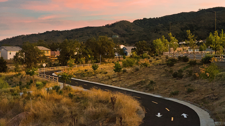 A sunset image of Gilroy in California featuring a newly paved road and beautiful hills