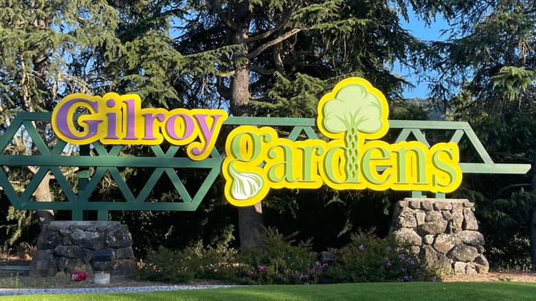 The entrance sign for Gilroy Gardens in Gilroy, California, featuring images of garlic