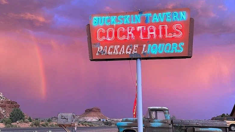 A rainbow, a rusty truck, and neon sign in Fredonia, Arizona