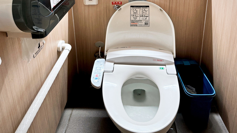 A public restroom with an electronic bidet