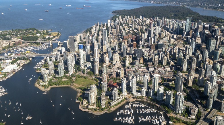Aerial view of Vancouver showing downtown skyscrapers surrounded by water and mountains