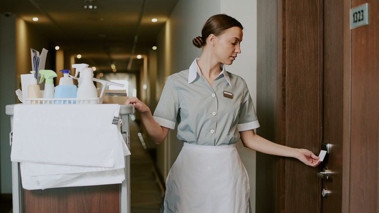 Hotel housekeeper entering a room.