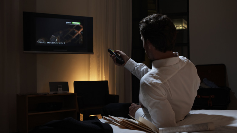 tired business traveler turns on hotelTV 