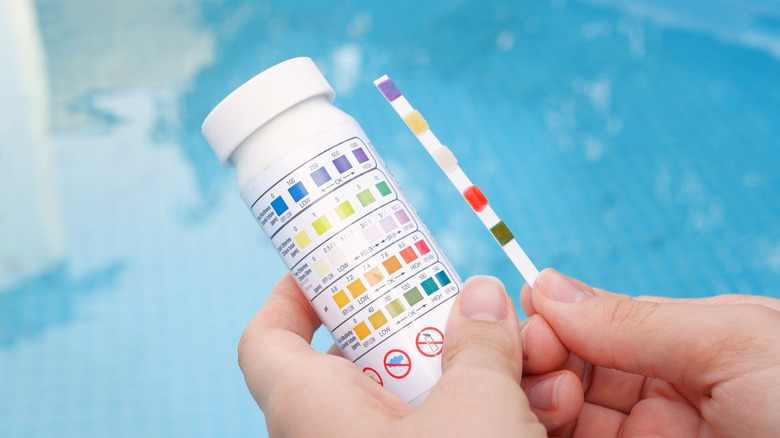 Someone testing a pool's chemicals