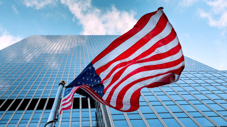 U.S. flag flying crumpled by the wind against skyscraper