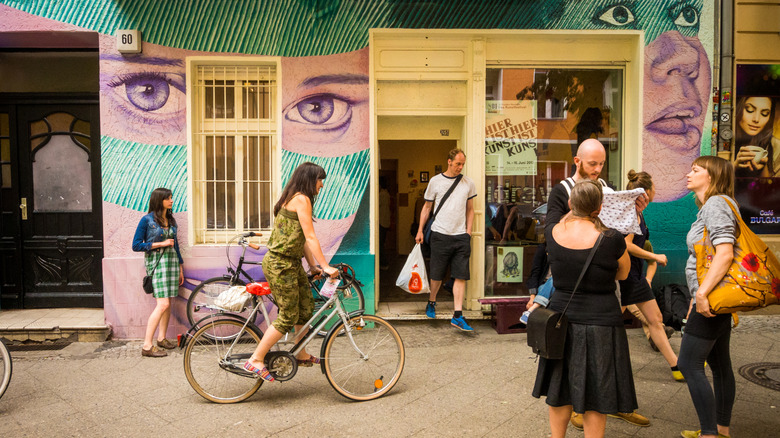 People standing outside shop with street art in Berlin