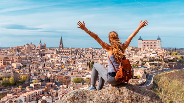 A backpacker sitting on a hill looking out over Toledo, Spain