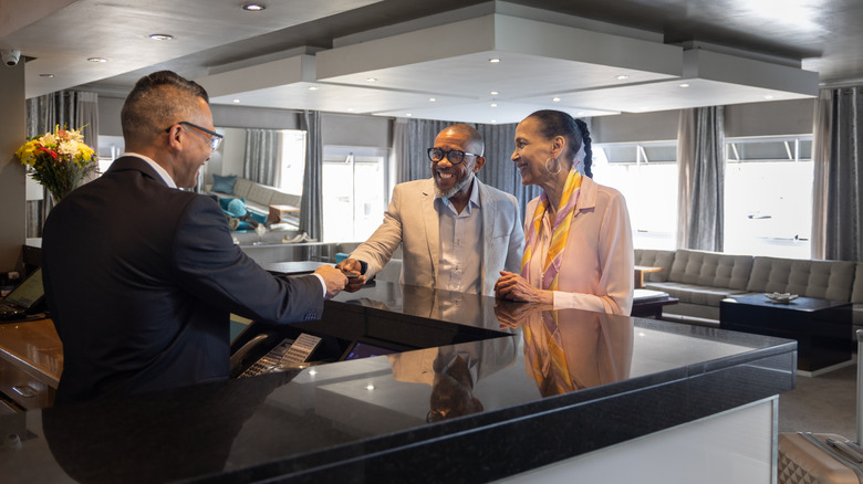 A couple giving their credit card to a hotel concierge