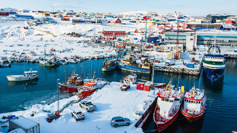 Boats and colorful buildings covered in snow in Ilulissat, Greenland