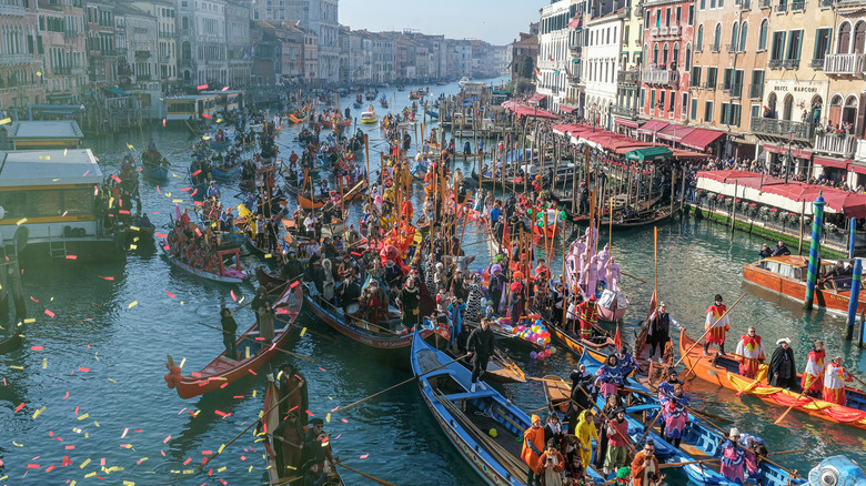 Colorful boats and people in costumes celebrating on the water during the Venice Carnival in Italy