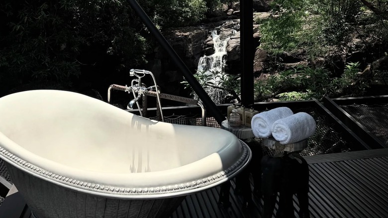 A freestanding bathtub overlooking the waterfall at Shinta Mani Wild