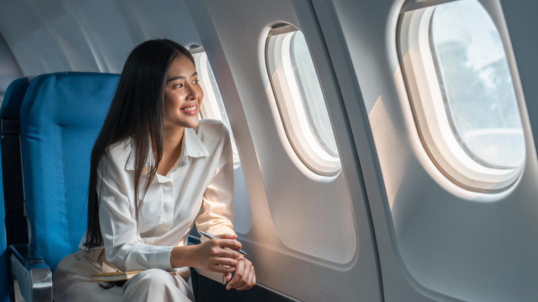 Asian woman looking out of an airplane window
