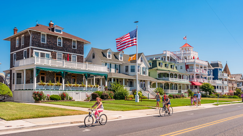 Cyclists pass by oceanfront Victorian houses in Cape May, NJ