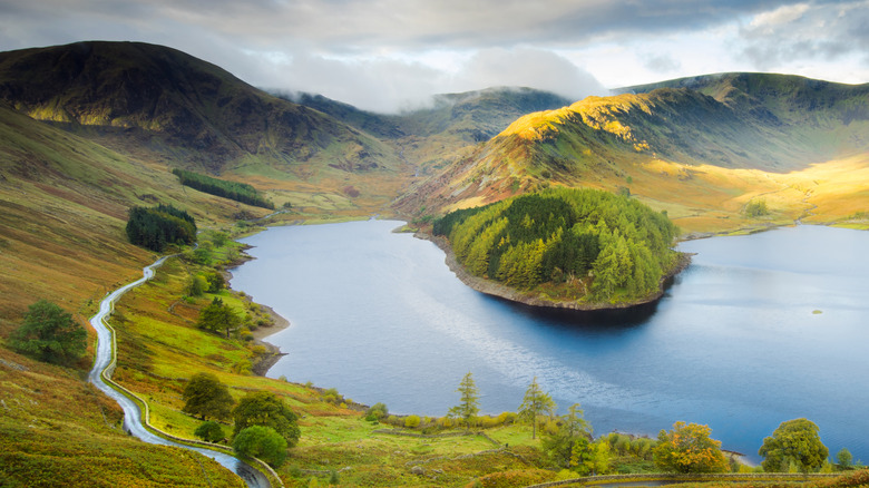 Sloping green hills lead to a horseshoe-shaped segment of Haweswater in England