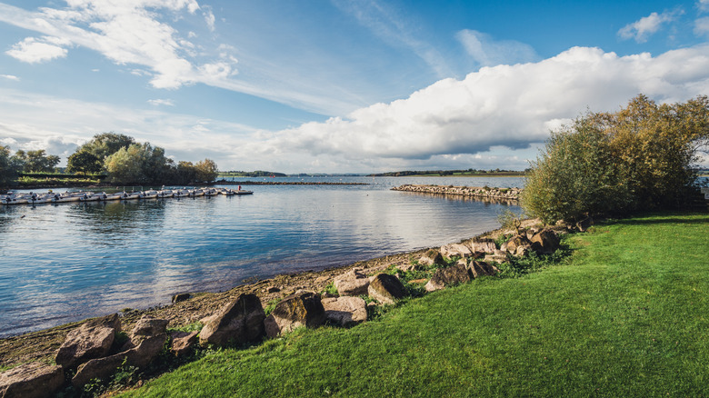 Rock-lined shores separate deep green grass from Rutland Reservoir