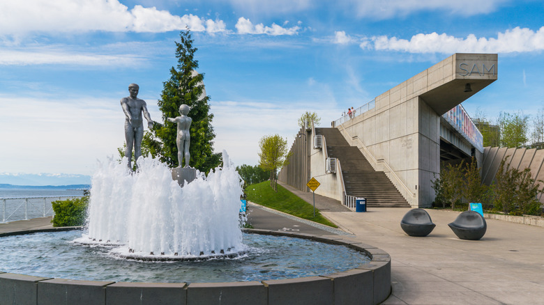 A fountain with two figure sculptures on it at the Olympic Sculpture Park in Seattle.