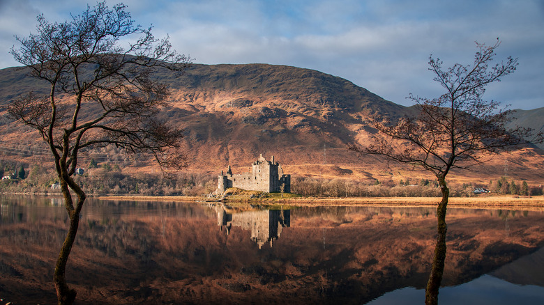 The famous ruins of Kilchurn Castle sit beneath rugged mountains on the shores of Loch Awe