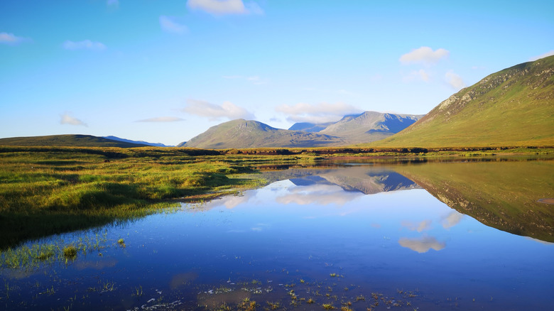The Ben Alder massif rises above the reflective waters of Loch Ericht