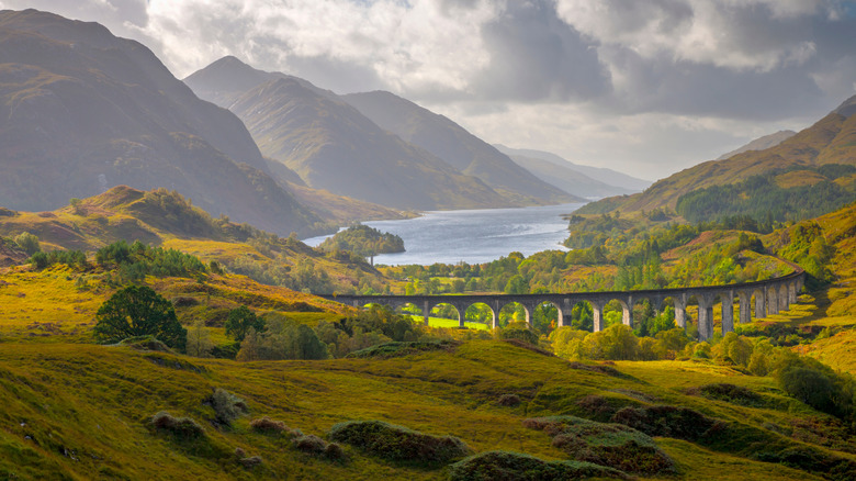 The Glenfinnan Monument and viaduct sit before the banks of mountain-shrounded Loch Shiel