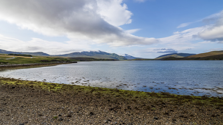 The wide waters of Loch Shin open under cloud-topped mountains