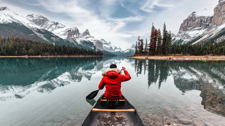 Man on canoe paddles on Maligne Lake.