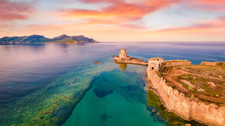 Sunrise over European castle on water
