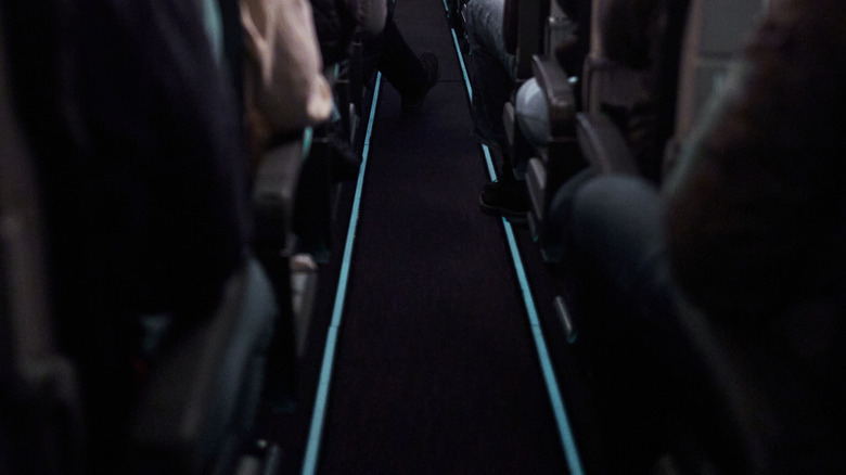 The lit up emergency floor path markers on an airplane