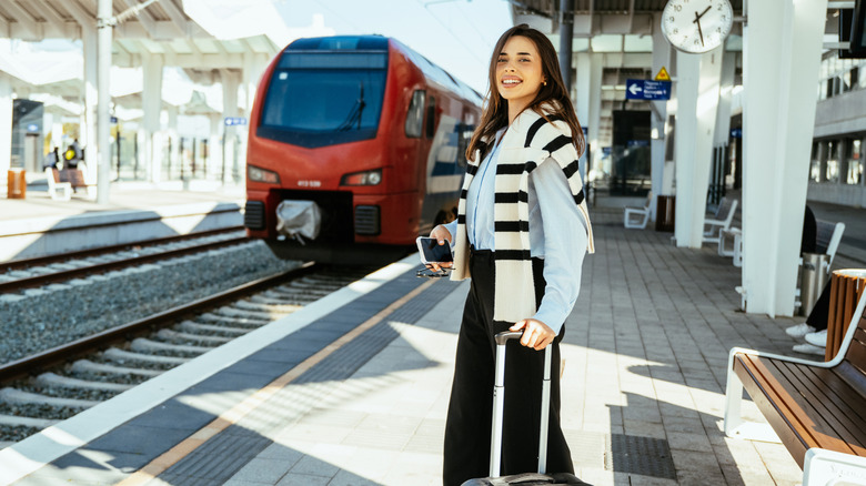 Woman at a train station platform with a suitcase