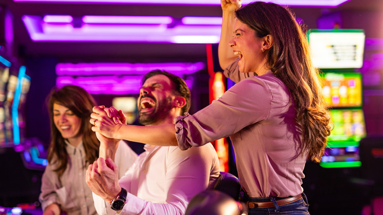 Friends enjoy a fun and thrilling experience at a stylish casino surrounded by neon lights