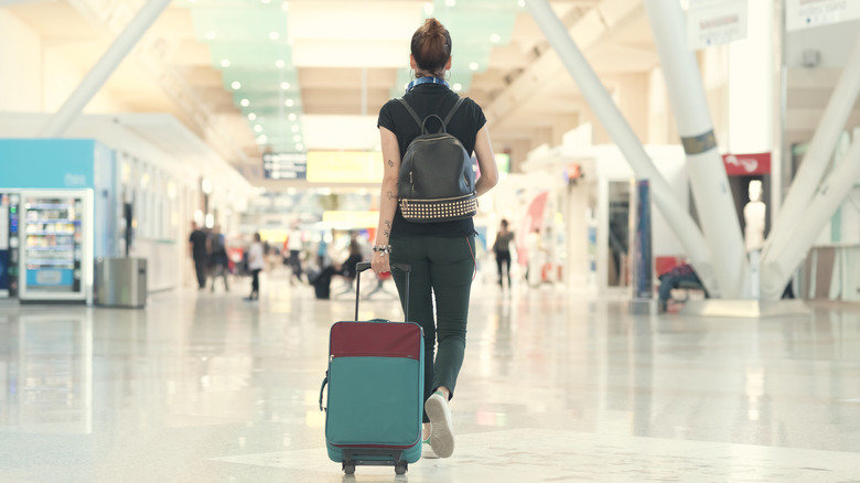 Person with a suitcase walking through an airport