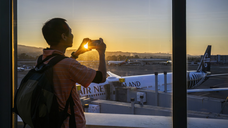 Person taking a picture during a quiet sunset at San Francisco Airport